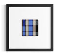 Inspired by stained-glass windows, a square black-framed contemporary wall art print with a white mat and a small central abstract plaid pattern in blue, beige, brown, black, and gray.