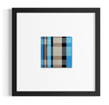 A square framed contemporary art print featuring a modern plaid pattern in shades of teal, beige, brown, black, and taupe, presented in a black frame with a white mat on a clean white background.