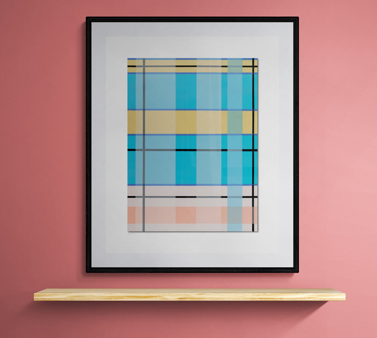A framed abstract geometric art print featuring blue, yellow, and pink plaid-like blocks, displayed on a pink wall above a light wood floating shelf.