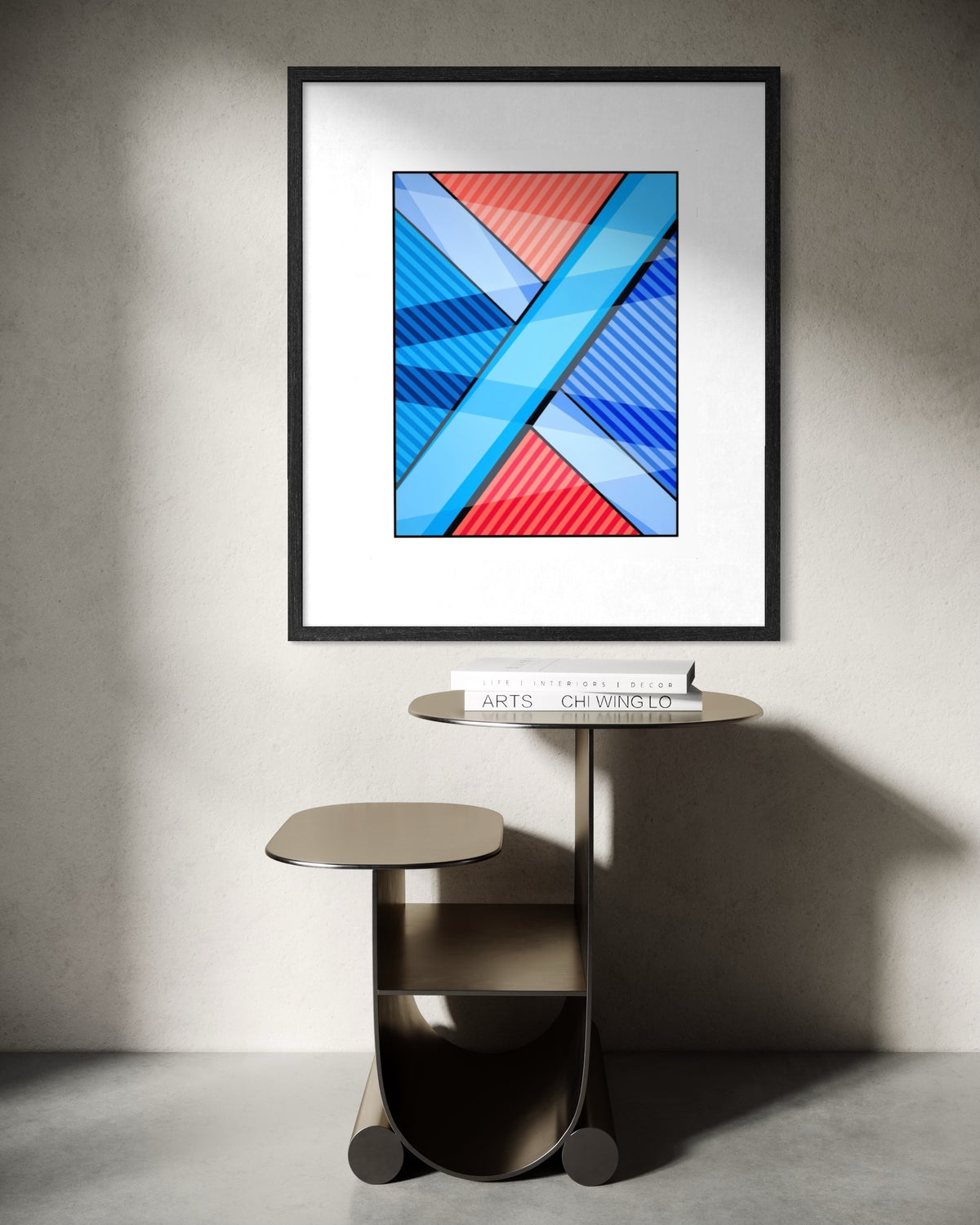 A framed abstract urban art print titled The Search and premised on the search for meaning in life with red, blue, and white shapes hangs on a light gray wall above a red metal chair in a sunlit room.